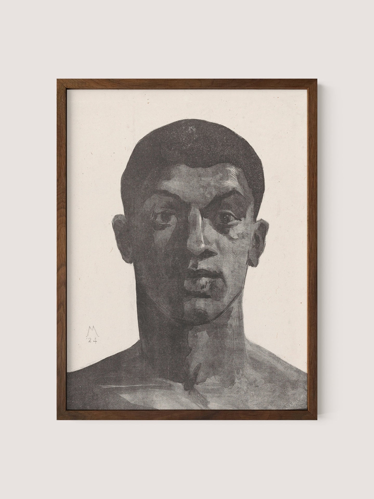 The Unknown Man, a framed black and white portrait in walnut oak, features a head and shoulders sketch of a man with a pensive expression and short hair, drawn in bold, dark strokes. The haunting graphite portrait, signed with an "M" and dated "'24", showcases a strong contrast in shading and detail.