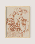 The "Seated Woman With Hat at Studio" is a framed line drawing depicting a person in a thoughtful pose, adorned in a large, patterned hat and an intricately detailed outfit. The reddish-brown lines create a striking contrast against the light beige background, making it an ideal addition to any gallery wall. The frame is finished in elegant natural oak.