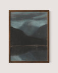 Evening in Štrbské Pleso" is a framed painting of a tranquil landscape composition featuring misty, dark mountains and a reflective body of water beneath a moody, cloudy sky. The frame is made of dark wood, beautifully showcasing this timeless work of art.