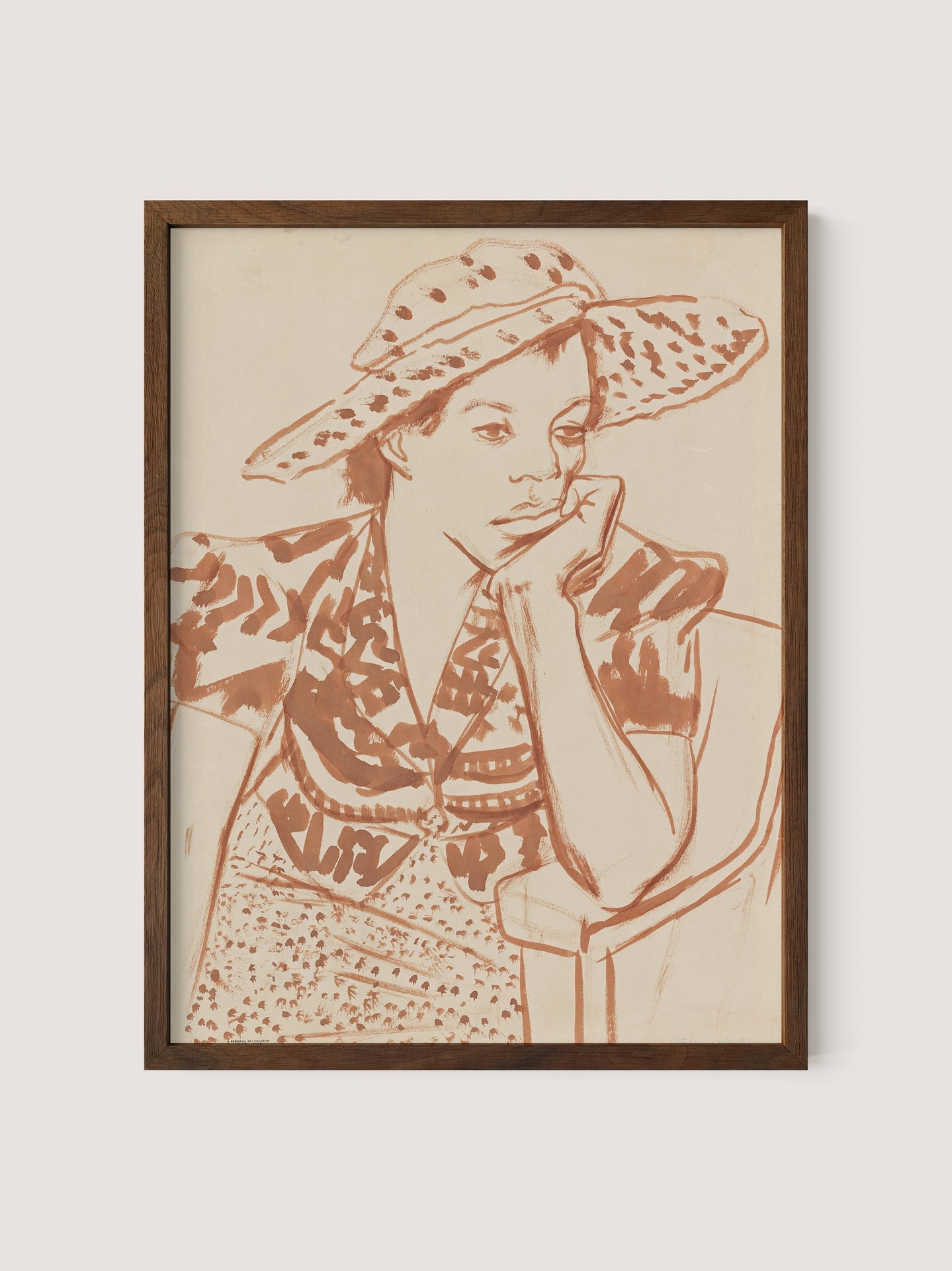 The Seated Woman With Hat at Studio depicts a pensive person resting their chin on their hand. Seated on a chair, the individual dons a wide-brimmed, patterned hat and a patterned blouse. The line drawing, framed in walnut oak, features earthy brown tones on a neutral background, making it an ideal piece for any gallery wall.