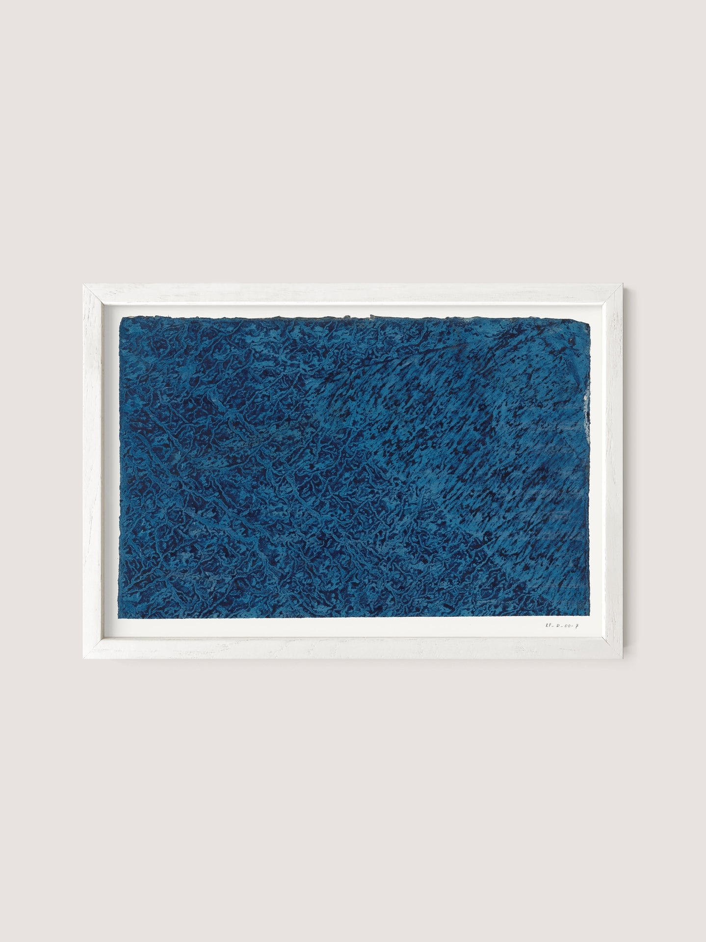 The Marbled Blue artwork, framed in elegant White Oak, showcases an abstract painting with a rich, textured dark blue surface. The background is a simple off-white shade. This piece features mesmerizing patterns of shades and brushstrokes, resulting in an intricate and layered appearance with timeless allure.