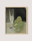 A framed painting titled "Green Apples And Champagne Glass" depicting a still life with green apples and a champagne glass on a table. The painting, distinguished by its muted earth tones, emphasizes a minimalist and expressive style, encapsulating timeless elegance. The frame is crafted in natural oak color.