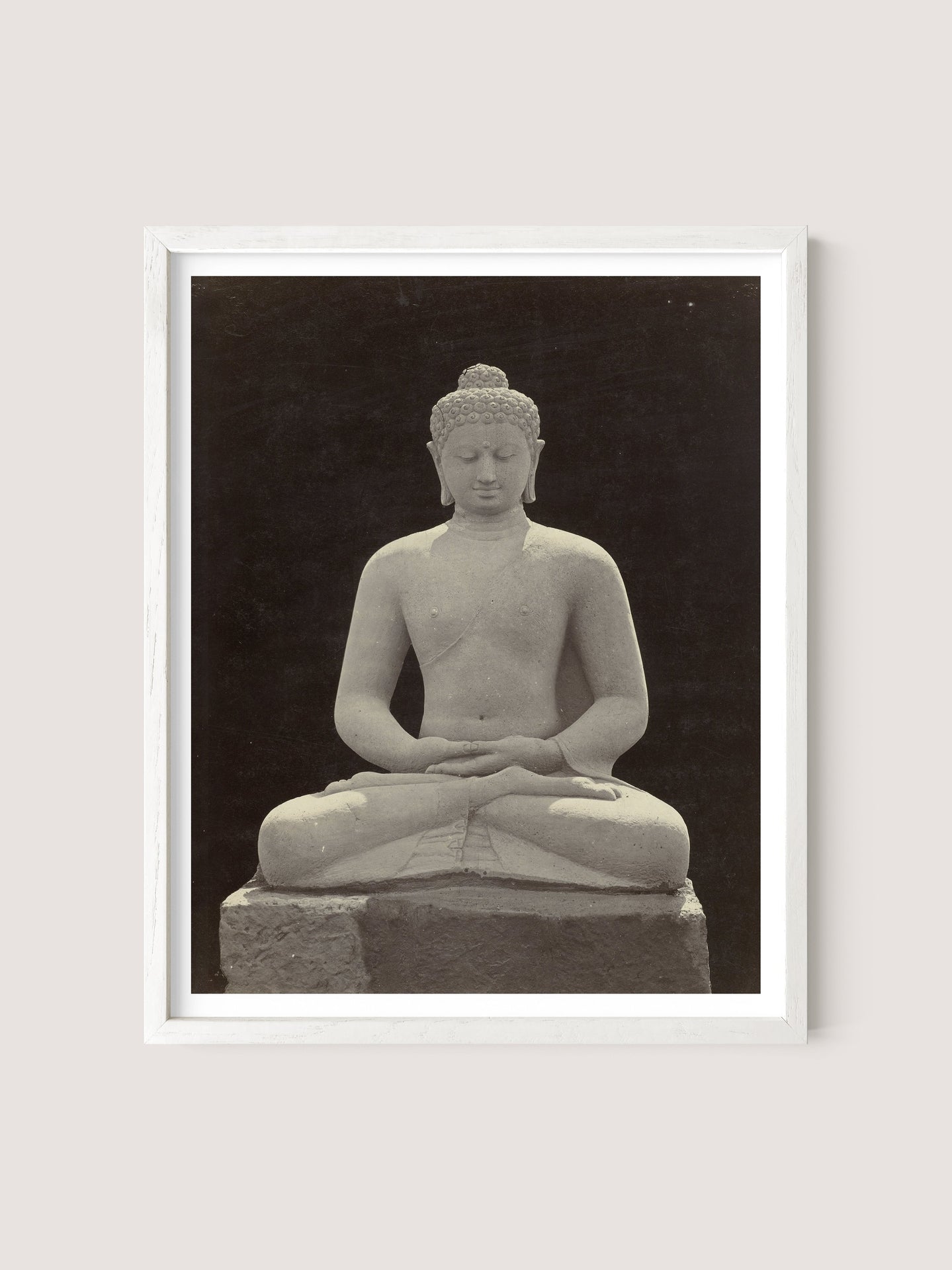 A framed photograph of a serene white oak Buddha Statue in a meditative seated posture against a dark background. The statue, reminiscent of those found in a Buddhist sanctuary, has a calm expression, closed eyes, and its hands resting on its lap in a traditional meditation pose.