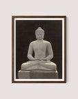 A walnut oak-framed photograph of the Buddha Statue, capturing an image of a seated Buddha with legs crossed and hands in a meditative position. The Buddha’s eyes are closed, evoking the serenity of a Buddhist sanctuary, with no visible background detail.