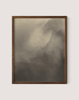 A framed photograph titled "Equivalents," reminiscent of Alfred Stieglitz's "Songs of the Sky," features a soft, abstract depiction of clouds or mist in shades of gray and white. The image, a gelatin silver print, appears tranquil and atmospheric with gentle contrasts and subtle details suggesting movement. The wooden frame has a simple, natural Walnut Oak finish.