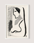 Thoughtful Woman" is a minimalist black and white illustration that evokes the image of a woman with long hair. This abstract artwork is characterized by bold, curvy lines and simple shading, lending it a stylish and modern appeal. The versatile ink drawing comes elegantly framed in a white oak frame, making it a sophisticated addition to various interior styles.