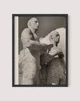 The framed black and white photo titled "Olympic Men, Berlin" encapsulates the essence of Paul Wolff's photography, featuring two stone statues often recognized as Berlin Olympic statues. The sculptures depict two muscular male figures, one slightly ahead of the other, gazing forward against a sky with a few clouds and are beautifully presented in a Black Oak frame.