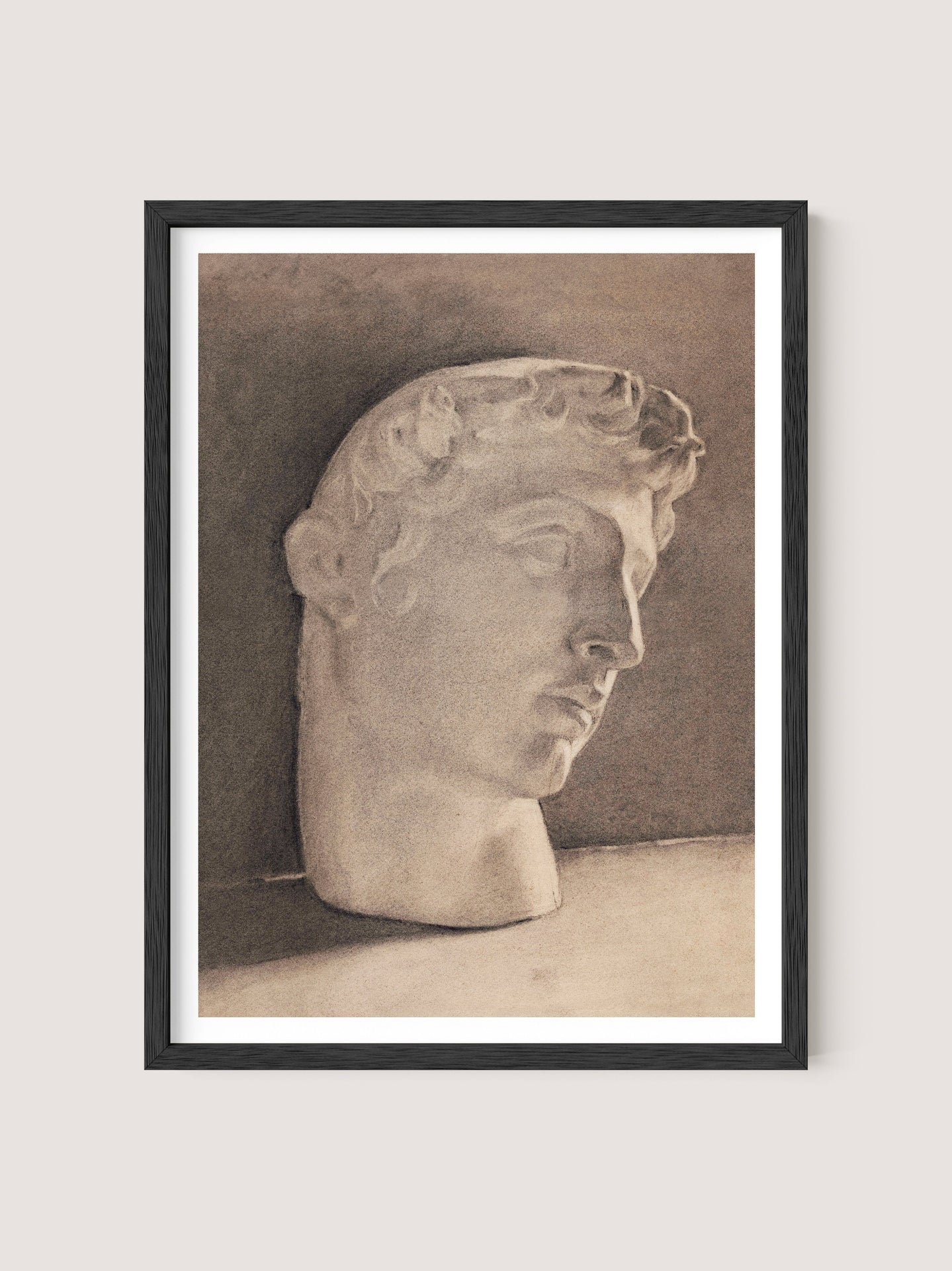 The "Study of a Plaster Head" is a framed pencil sketch of a neoclassical statue head in Black Oak, featuring fine, detailed lines and shading. The head, with curly hair and a serene expression, is tilted slightly to the right. The shaded background lends elegance and depth, enhancing the three-dimensional effect.