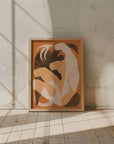 The artwork, *Swan Study I*, with its framed abstract depiction of dark brown and white shapes, is propped against a textured, light-colored wall. Sunlight from an unseen window casts shadows across the floor and wall, creating a warm and serene atmosphere in the room, as if mimicking a poetic dance of light and shadow.