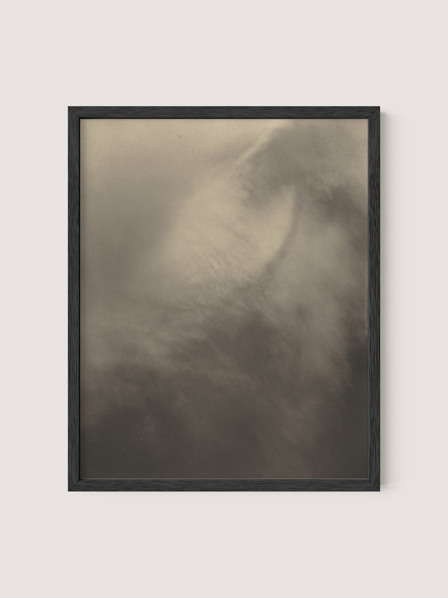 A framed photograph titled "Equivalents" features an abstract, blurred image dominated by soft, muted shades of brown and gray. The indistinct shapes create a sense of motion and mystery, resembling a foggy or cloud-like scene. Reminiscent of Alfred Stieglitz's "Songs of the Sky," the black oak frame has a simple design.