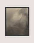 A framed photograph titled "Equivalents" features an abstract, blurred image dominated by soft, muted shades of brown and gray. The indistinct shapes create a sense of motion and mystery, resembling a foggy or cloud-like scene. Reminiscent of Alfred Stieglitz's "Songs of the Sky," the black oak frame has a simple design.