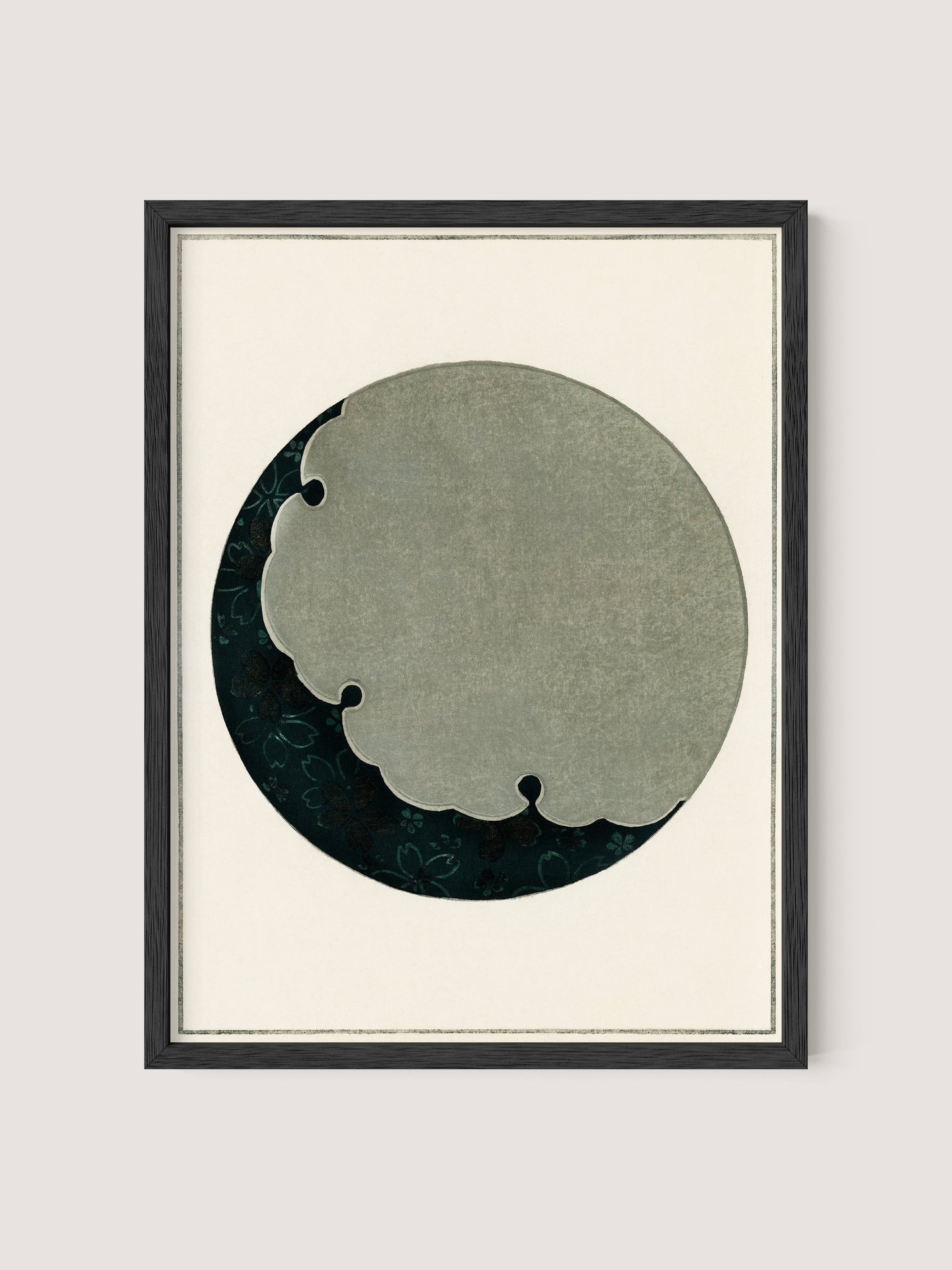 A framed abstract artwork titled "Moon," inspired by the Japanese aesthetic, features a circular shape with a cloud-like cutout design. The circular area has a dark green, textured background with a floral pattern, while the cutout portion is in a lighter greyish-green color. The frame is minimalist and made of Black Oak.