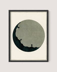 A framed abstract artwork titled "Moon," inspired by the Japanese aesthetic, features a circular shape with a cloud-like cutout design. The circular area has a dark green, textured background with a floral pattern, while the cutout portion is in a lighter greyish-green color. The frame is minimalist and made of Black Oak.