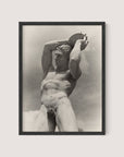 A black and white photograph of The Discus Thrower, a nude male statue holding a disc above his head with both hands. The statue appears muscular and detailed, with a focus on strong posture and serene expression. Paul Wolff's striking image is elegantly framed in Black Oak.